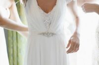 a sophisticated intricate lace A-line wedding dress wiht a vintage feel, a sash with rhinestones  are a gorgeous combo for a wedding