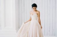 a strapless blush wedding ballgown with a draped and embellished bodice and a layered full skirt