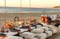 a stylish beach picnic bridal shower with white furniture and pillows, with dark linens, bold blooms and a lounge next to the table