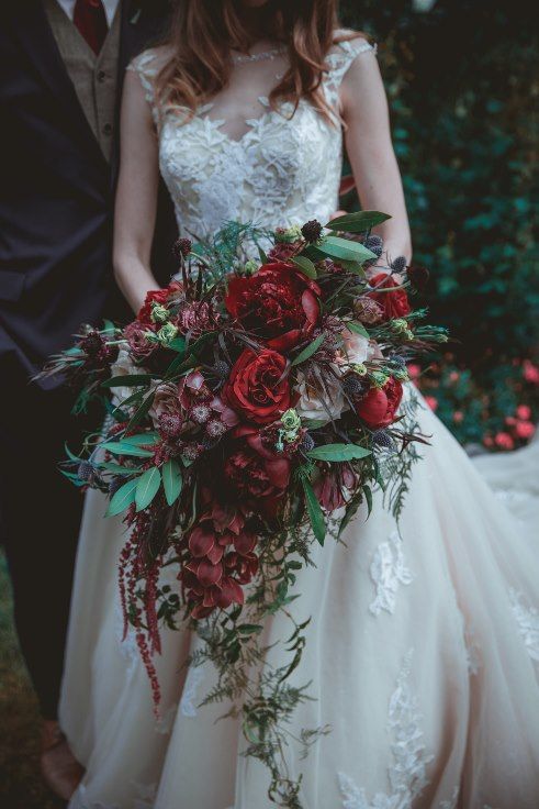 an oversized red wedding bouquet of peonies, roses and proteas, greenery and cascading amaranthus is a beautiful idea for the fall