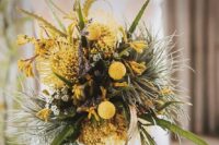 an unusual wedding bouquet of various greenery, yellow blooms and billy balls, astilbe looks textural and very pretty