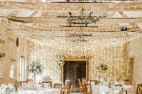 canopies of string lights hanging over the venue and vintage chandeliers are amazing to make the barn reception welcoming and cool