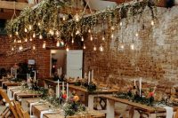 lovely lighting pieces of wooden ladders, greenery and Edison bulbs hanging down and tall and thin candles on the table