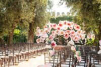 oversized pink paper blooms for styling a wedding backdrop and wedding aisle are a very-eco-friendly idea to try