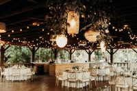 string lights and pendant lamps with crystal shades and lots of greenery are amazing for a rustic or boho wedding venue