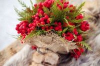 a berry and evergreen wedding bouquet with a fur and burlap wrap is a bold idea for a rustic winter bride