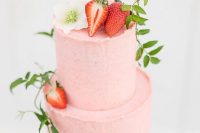 a blush wedding cake topped with a white bloom, strawberries and some greenery is a beautiful idea for a summer wedding