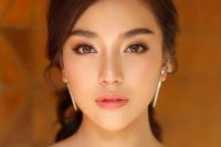 a chic Asian wedding makeup with a matte nude lip, blushes, brown eyeshadows and eyeliner and statement eyebrows
