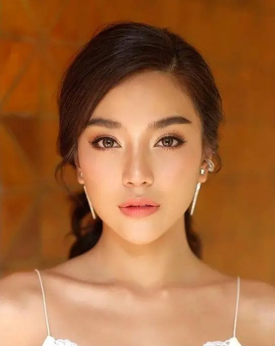 a chic Asian wedding makeup with a matte nude lip, blushes, brown eyeshadows and eyeliner and statement eyebrows