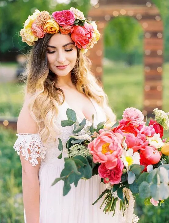 a colorful large flower crown in red, yellow and orange and a matching wedding bouquet