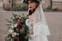 a dramatic and contrasting oversized flower crown with pink, neutral and deep purple blooms, greenery and a veil with fringe attached