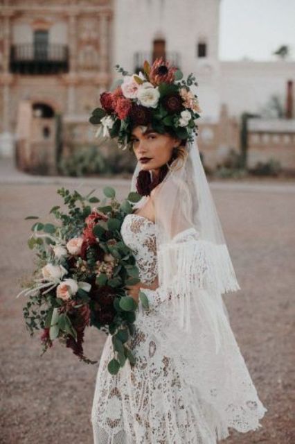 a dramatic and contrasting oversized flower crown with pink, neutral and deep purple blooms, greenery and a veil with fringe attached