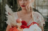 a dramatic flower crown with pink, red, peachy, blush and orange blooms, a matching bouquet and a deep red lip for a summer wedding