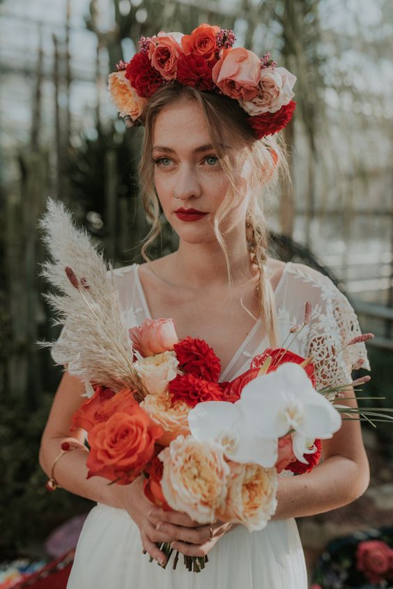 a dramatic flower crown with pink, red, peachy, blush and orange blooms, a matching bouquet and a deep red lip for a summer wedding