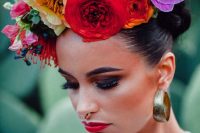 a fantastic and bright flower crown with purple, deep red, yellow, pink blooms and berries for a Frida Kahlo bridal look