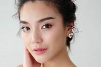 a fresh Asian wedding makeup with a matte nude lip, brown eyeshadows, statement eyebrows and glowy skin