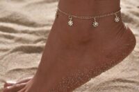 a gold chain and a flower charm anklet are an amazing and chic combo for a boho bride, not only a beach one