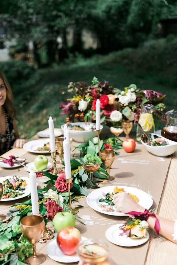 a gorgeous al fresco fall bridal shower setting with a greenery and bloo runner, apples and gilded touches