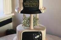 a gorgeous black and white Star Wars wedding cake with white baby’s breath, a black silhouette cake topper and themed decor