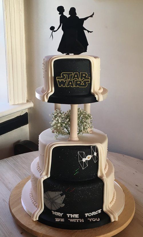 a gorgeous black and white Star Wars wedding cake with white baby's breath, a black silhouette cake topper and themed decor