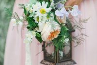 a lantern wedding bouquet covered with lush blooms and greenery is a fresh and non-traditional idea for a bride
