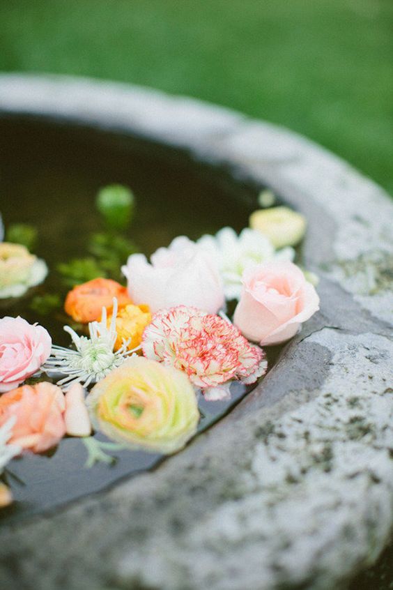 a large bowl with pastel and bold blooms floating inside is a lovely idea for a refined and chic wedding