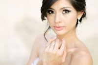 a lovely Asian wedding makeup with bold black eyeshadows and statement eyeliner, with a matte pink lip and light pink blush
