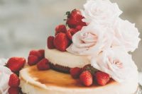 a lovely two-tier wedding cheesecake with fresh strawberries and blush roses is a very beautiful idea to try