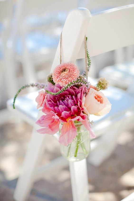a mason jar with bright blooms is a cool decoration for a wedding aisle, it can be easily DIYed