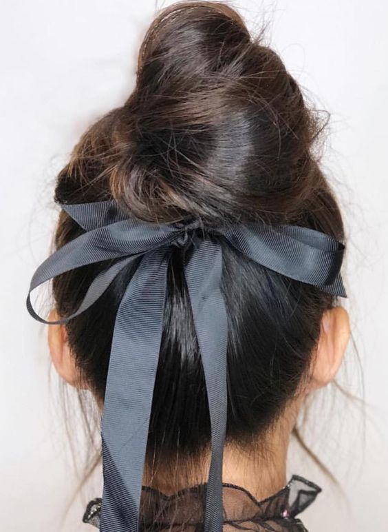 a messy twisted top knot with a graphite grey ribbon bow is a very refined and chic idea for a pretty bridal look