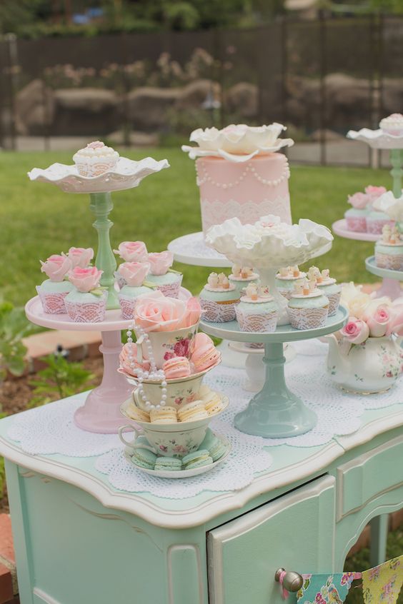 a mint table with doilies, with vintage pastel sweet and cake stands, beautiful cakes, cupcakes and pastel blooms and macarons