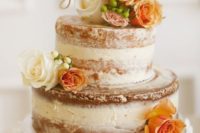 a naked bridal shower cake with orange and white blooms and an elegant calligraphy topper