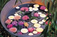 a rustic wedding decoration – a glavanized bathtub with floating blooms and candles is a lovely and easy to realize idea