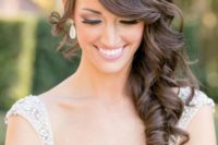 a side curl wedding hairstyle with a bang looks luxurious and vintage-inspired