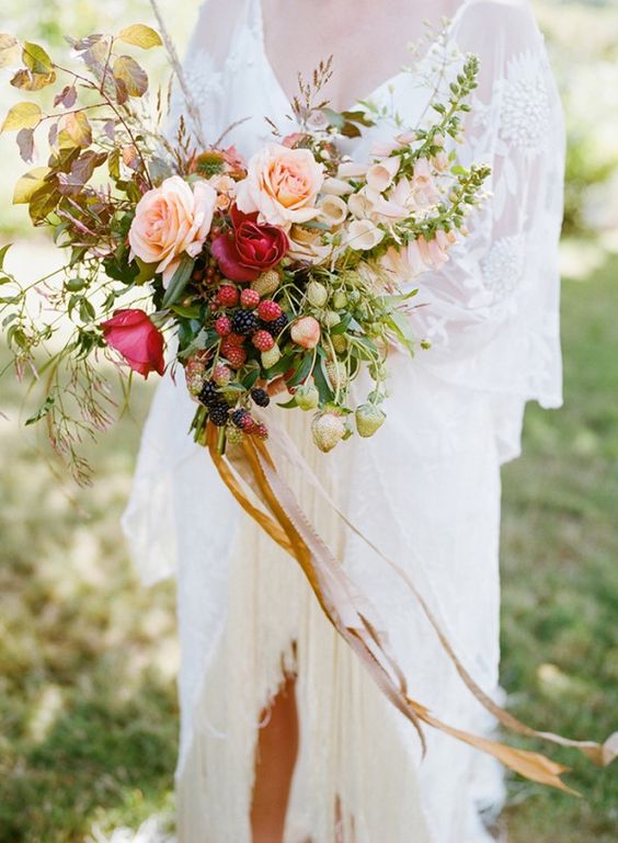 a summer wedding bouquet with blush and burgundy roses, fresh berries and lots of greenery and foliage is amazing