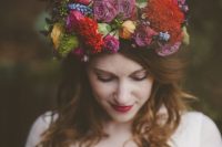a super bold jewel tone flower crown with mauve, deep red, yellow and blue blooms and some dark foliage for a bold fall wedding