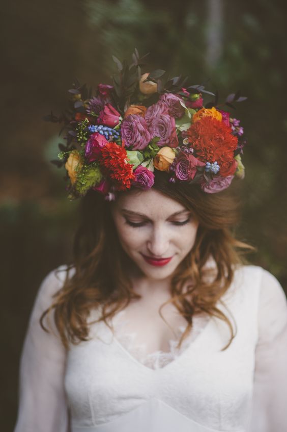 a super bold jewel tone flower crown with mauve, deep red, yellow and blue blooms and some dark foliage for a bold fall wedding