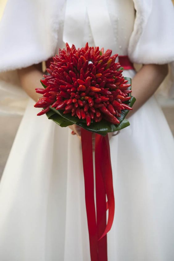 a super creative wedding bouquet of red ho chili peppers, with foliage and red ribbons is a gorgeous solution to add a hot touch