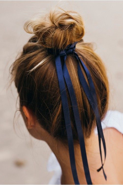 a super messy top knot with a navy ribbon accenting it is a creative idea that works evne if your hair isn't super long