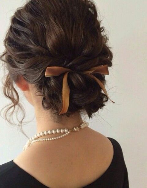 a twisted and braided low updo on medium hair, with wavy locks down is a chic idea for a girlish look
