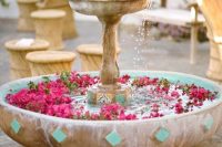 a vintage fountain with floating hot pink blooms is a lovely idea for an outdoor wedding, they will add color