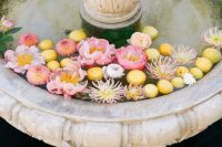 a vintage fountain with floating pink peonies and citrus is a lovely idea for a summer-like wedding