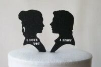a wedding cake topped with silhouettes of Lea and Han Solo and their favorite phrases