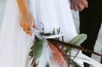 a whimsy boho wedding bouquet with feathers and leaves is a very creative solution for a fairy-tale or boho wedding