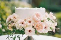a white buttercream wedding cake with neutral and blush blooms and greenery is a chic idea for a vintage bridal shower