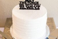 a white textural wedding cake with a black silhouette cake topper is a lovely idea for the fans
