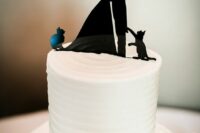a white textural wedding cake with a black silhouette couple cake topper including two cats of the couple