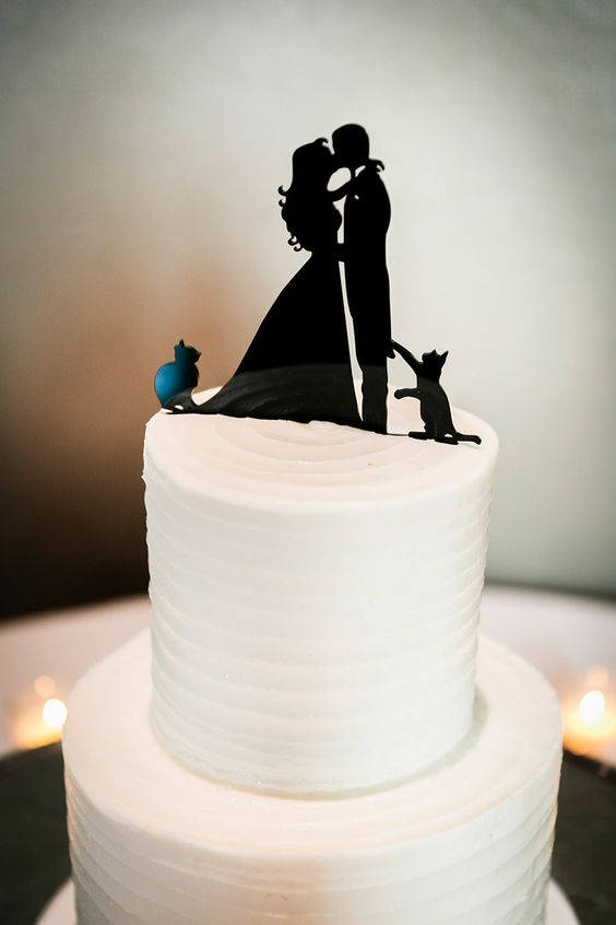 a white textural wedding cake with a black silhouette couple cake topper including two cats of the couple
