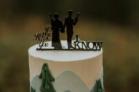 a woodland wedding cake with a black silhouette cake topper is a stylish idea for a themed wedding or for a couple who are fans of the saga
