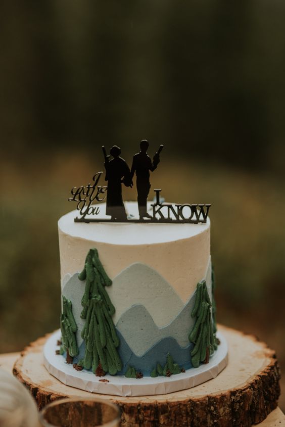 a woodland wedding cake with a black silhouette cake topper is a stylish idea for a themed wedding or for a couple who are fans of the saga